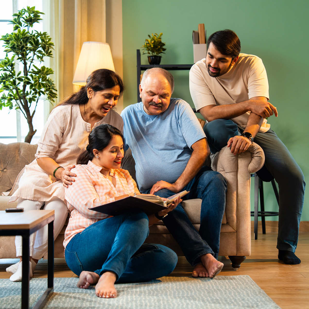 Glpckliche Familie schaut sich ein Fotoalbum an.