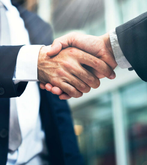 Geschäftspartner besiegeln eine erfolgreiche Zusammenarbeit mit einem Handschlag.