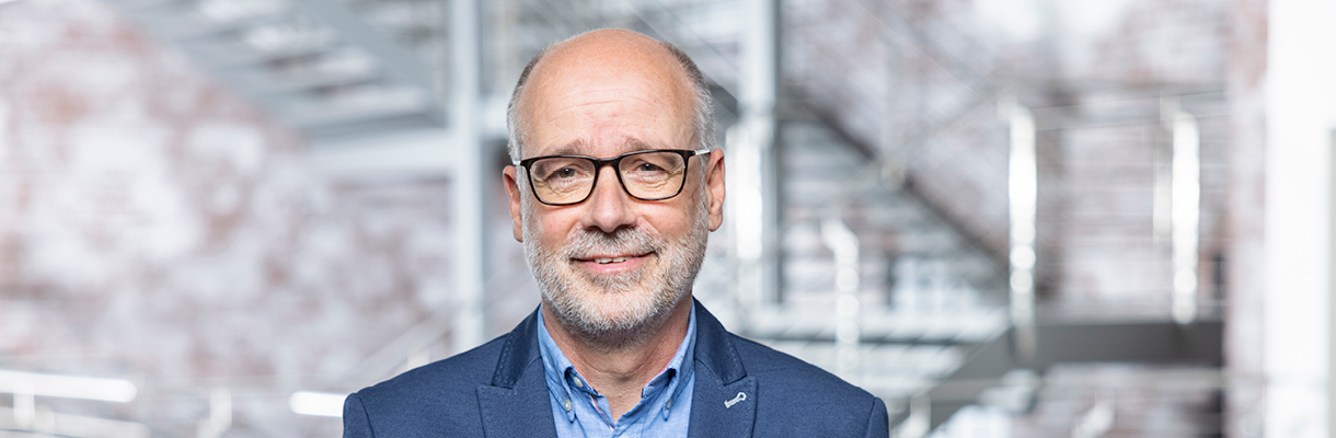 Porträtfoto von Jürgen Büchel, Mitglied der Alliance, in einem modernen Bürogebäude.