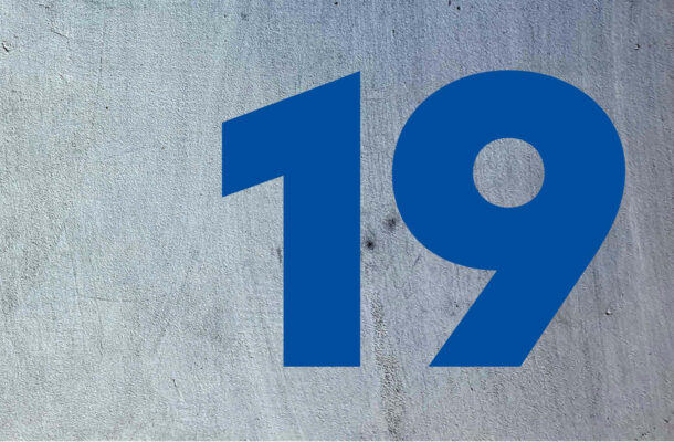 Großformatige blaue Zahl 19 auf Betonhintergrund