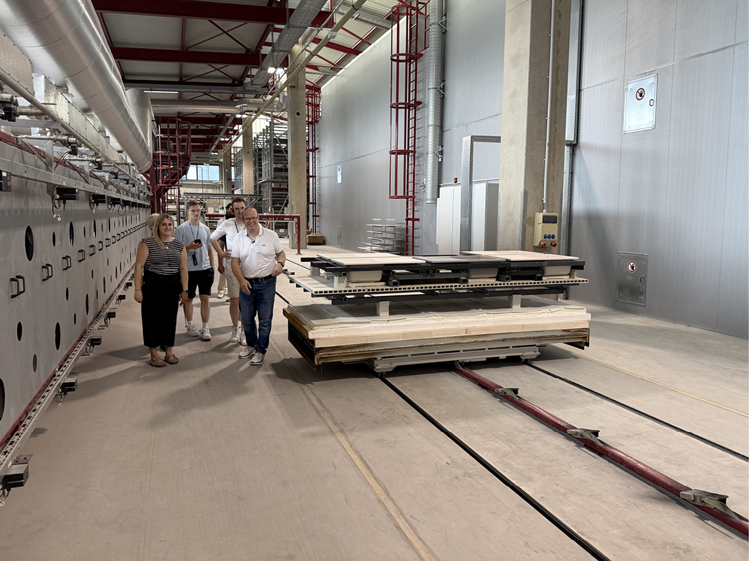 Rundgang durch eine moderne Fertigungshalle für Küchenkomponenten mit Besuchergruppe, passend zu Küchenmöbeln, Küchenplanung und Designküchen.