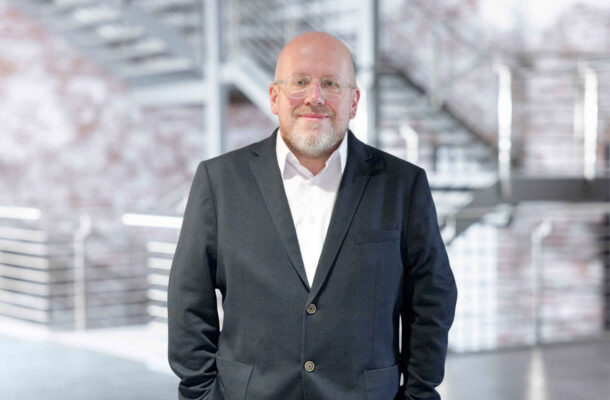 Douglas Potschatka vom Alliance-Verband im schwarzen Sakko vor modernem, hellen Interior-Hintergrund – Ansprechpartner für Küchenstudio, Küchenplanung, Küchenmöbel und Designküchen im Wohn- und Küchenbereich.