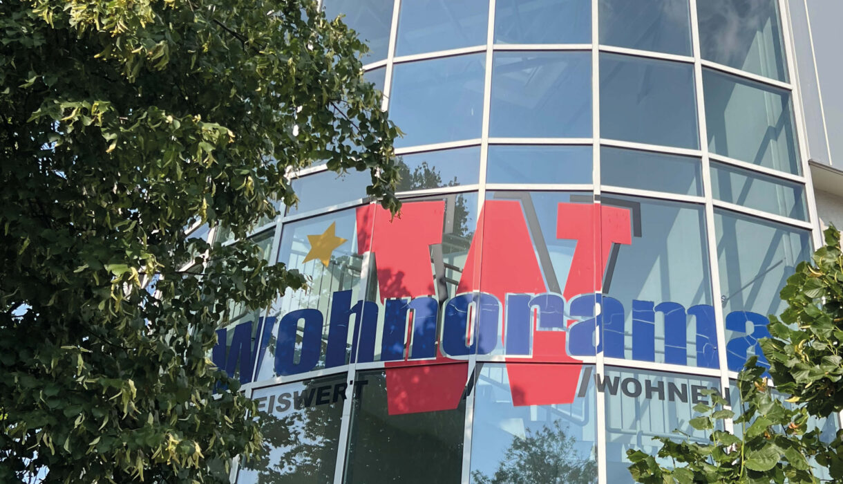 Headerbild zeigt Glasfassade mit Schriftzug von wohnorama wohnen