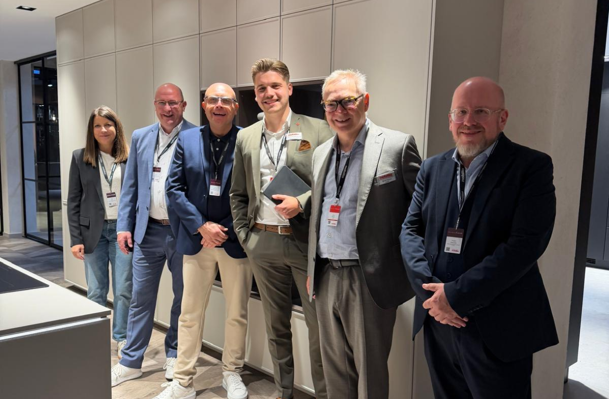 Gruppenfoto von sechs Messebesuchern vor einer modernen Küchenfront.