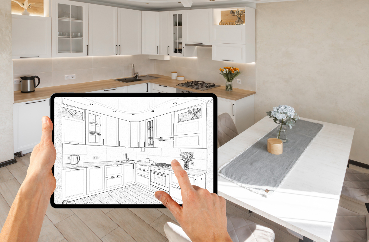 Digitale Küchenplanung auf einem Tablet vor einer hellen Küche mit weißen Fronten und Holzarbeitsplatte.